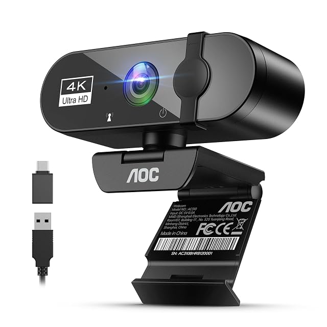 Webcam 4K AOC AC310 nera con copertura scorrevole sull’obiettivo, inclinata verso l’alto sul suo morsetto